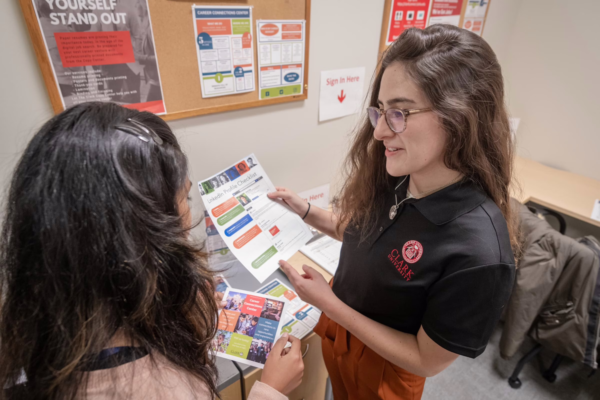 Career counselor reviewing linkedin document with other tudent