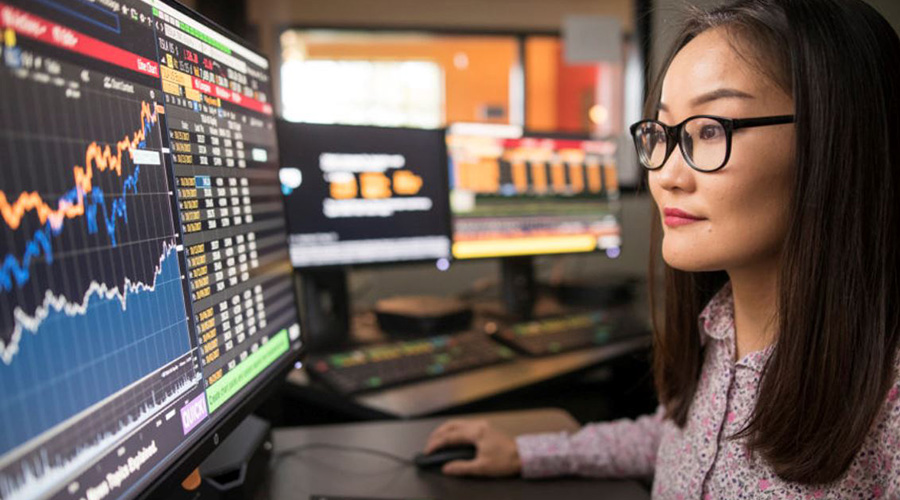 Finance student sitting behind computer screen with analytics
