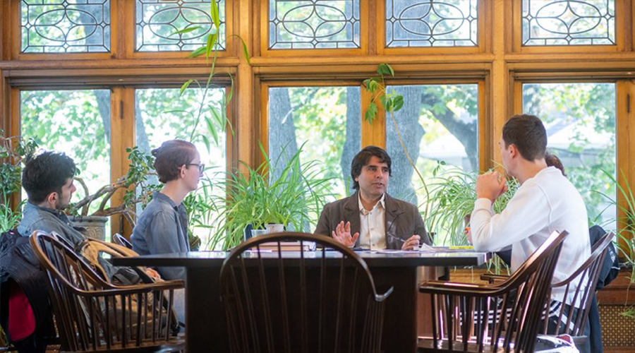philosophy professor with students around table