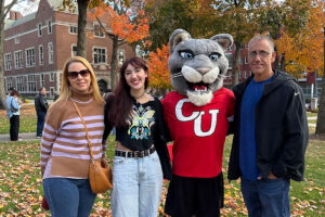 a family poses with the cougar mascot
