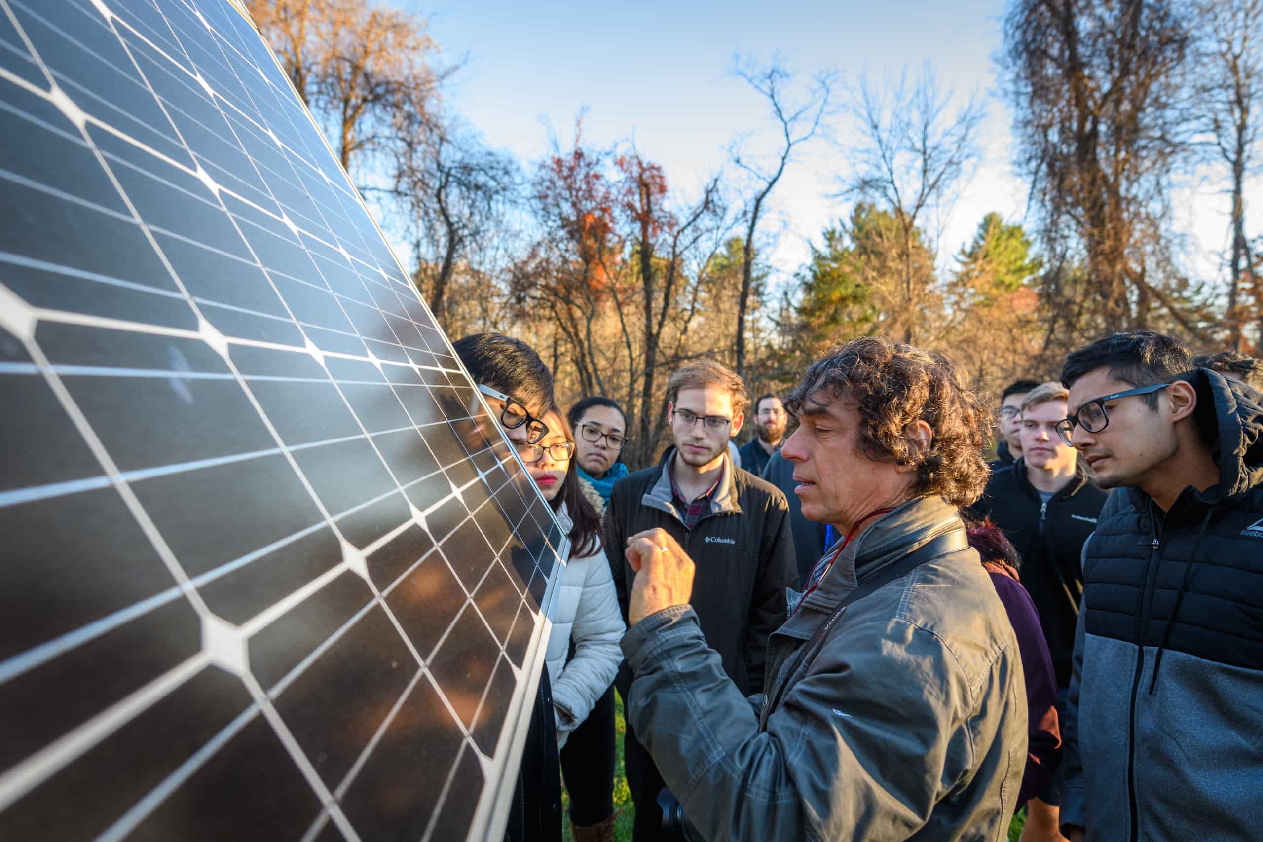 A class gathers around solar panels
