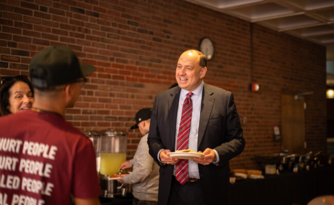 man in business suite talking to someone in Anne's Kitchen