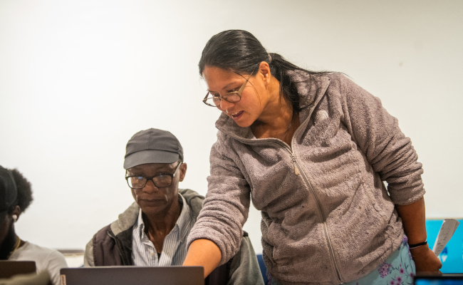 Professor shows student something on laptop