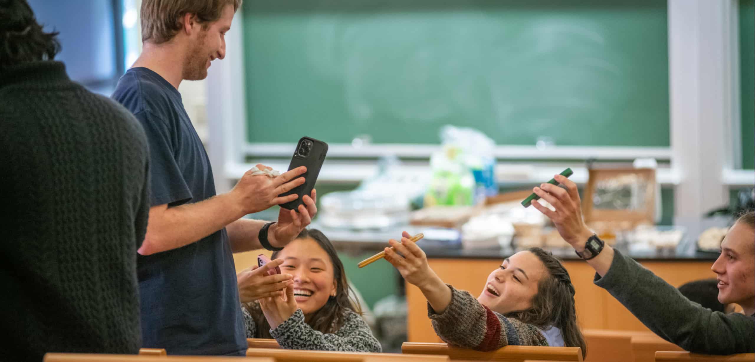 Students interact with one another with their phones