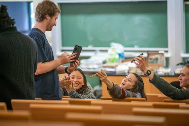 Students interact with one another with their phones
